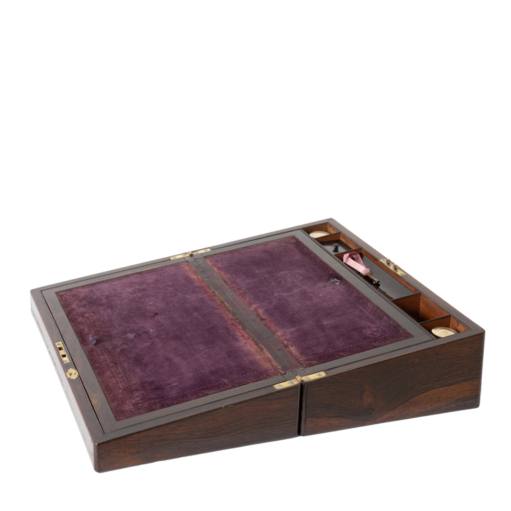 A wooden folding campaign box with a dark brown wood grain exterior, gold-tone metal hinges, and a purple velvet interior lining.
