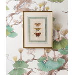 A framed art print featuring three vintage butterfly illustrations, displayed on a wall with a matching botanical patterned wallpaper.