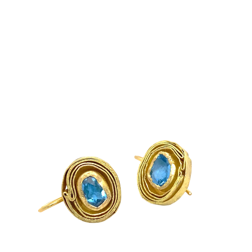 Gold earrings with blue gemstones on a white background