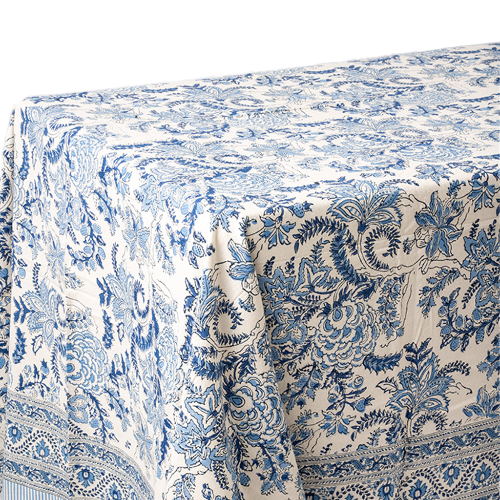 A close-up of a tablecloth with a blue and white floral toile pattern, draped to show its texture and border design.