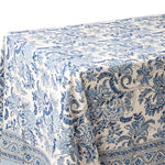 A close-up of a tablecloth with a blue and white floral toile pattern, draped to show its texture and border design.