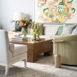 Modern living room with a sofa, armchair, coffee table, and decorative elements.