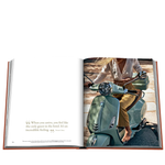 Open book showing a person on a scooter with a scenic background