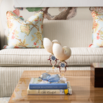 Square decorative pillow with robin egg blue background and floral pattern in soft yellow and green.