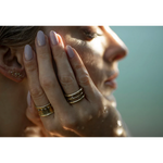 Close-up of a woman's hand with gold rings and a blurred background