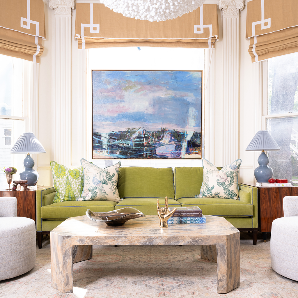 Living room with green sofa, wooden coffee table, and abstract painting on wall