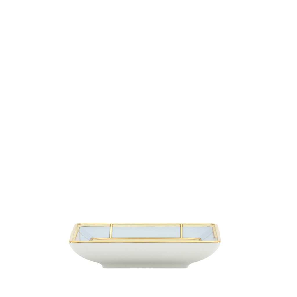 A light blue and yellow, square-shaped porcelain change tray with gold geometric patterns on the border, side view.