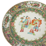 Decorative ceramic plate with colorful floral and figural design on a white background