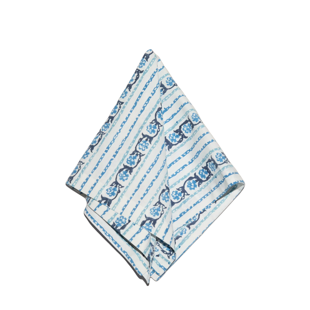 A folded napkin featuring a blue and navy floral pattern and vertical stripes, displayed on a clean white background.