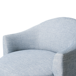 Close-up of a light blue upholstered chair with a textured fabric on a white background