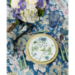 Set of six cobalt blue highball glasses with a vertical ribbed texture on a floral patterned tablecloth.