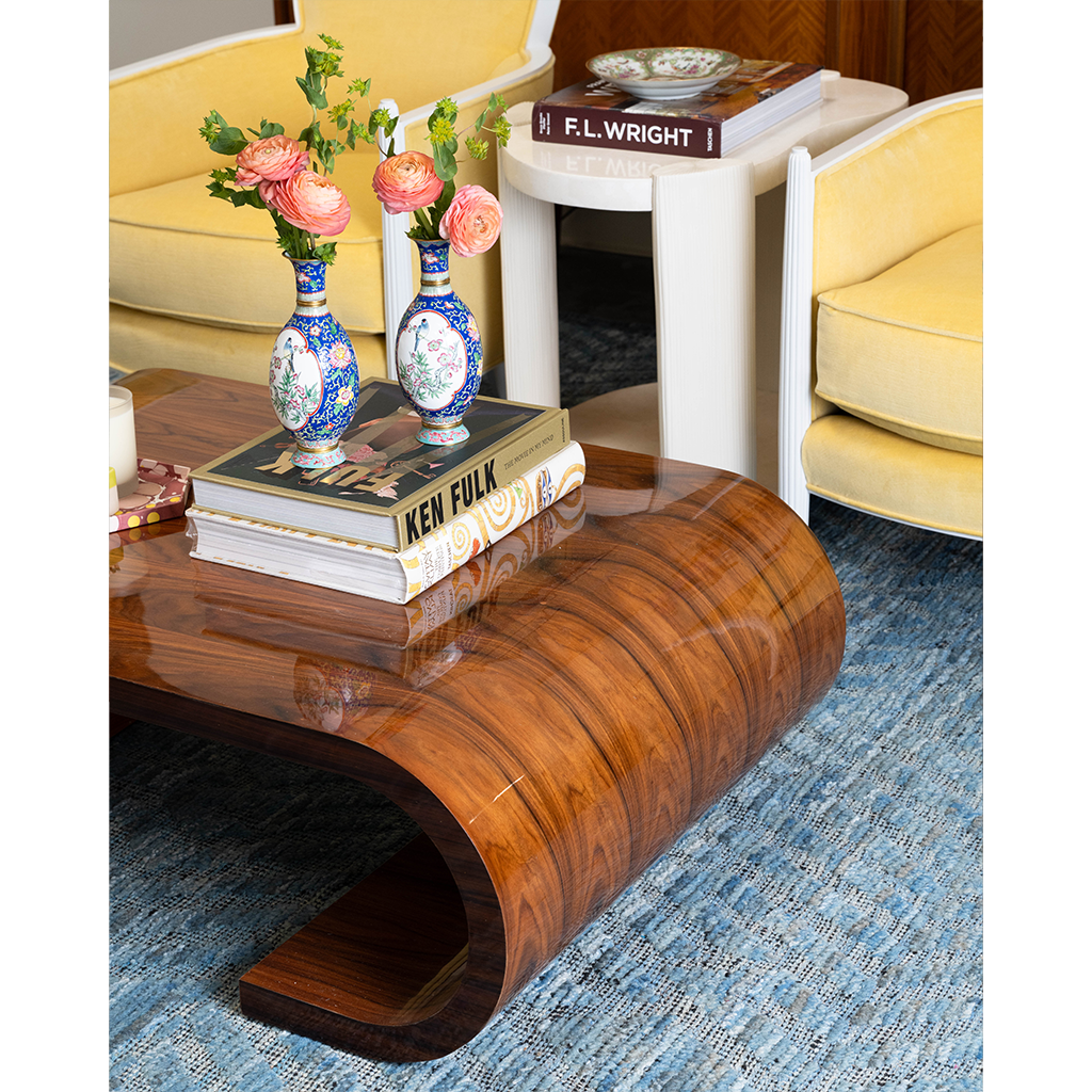 brown coffee table with books and vases on top