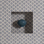 Blue decorative object on a patterned fabric background