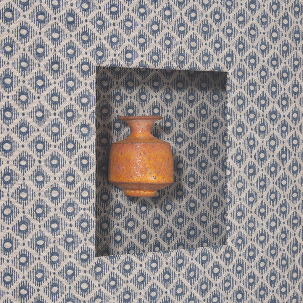 Small brown vase on a patterned blue and white background