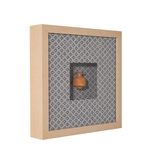Decorative box with a small brown vase on a patterned fabric background