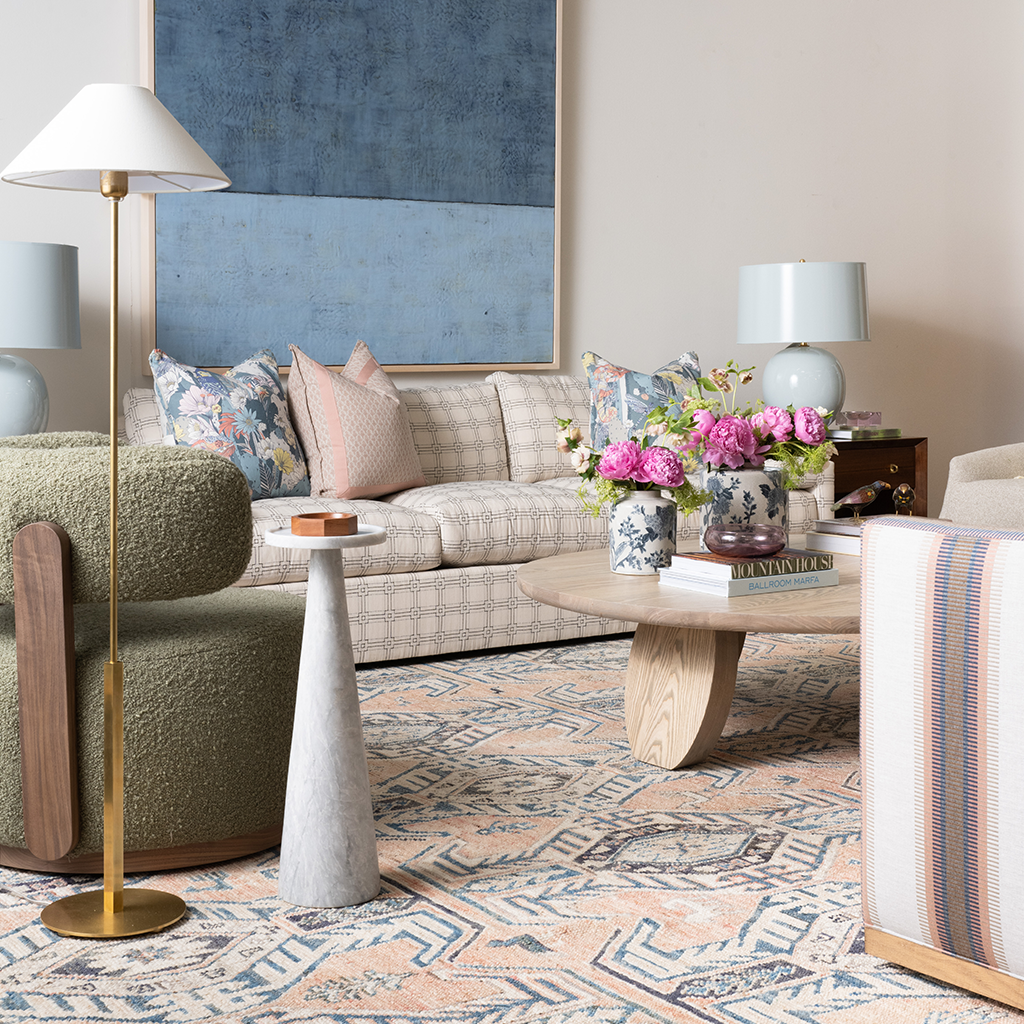 Light beige plaid sofa with tufted cushions and pastel accent pillows in a modern living room setting.
