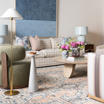 Light beige plaid sofa with tufted cushions and pastel accent pillows in a modern living room setting.