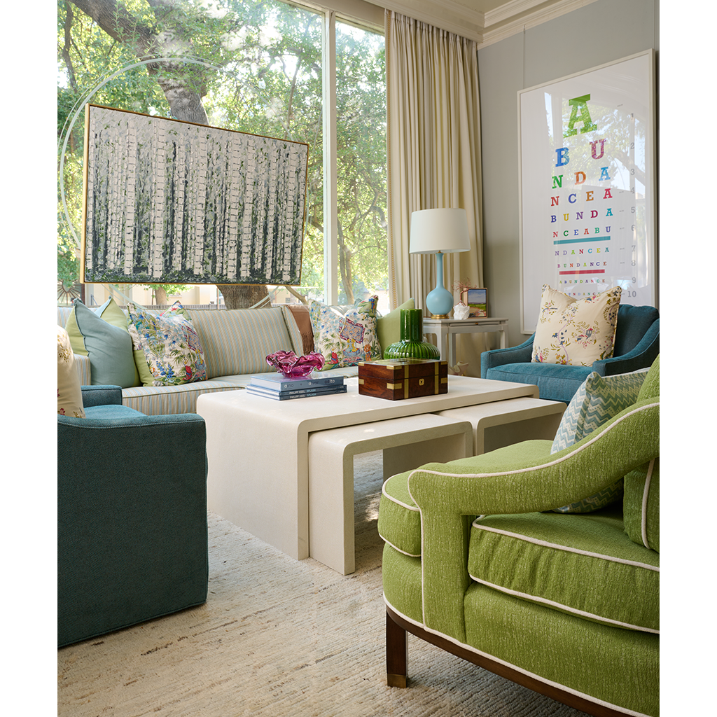 Rectangular lumbar pillow with blue zigzag pattern on white, placed on neutral-toned sofa in bright living room.