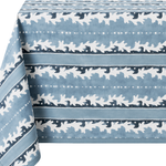 A blue tablecloth with a white repeating pattern of stylized leaves and dotted horizontal stripes, shown draped over the edges against a white background.