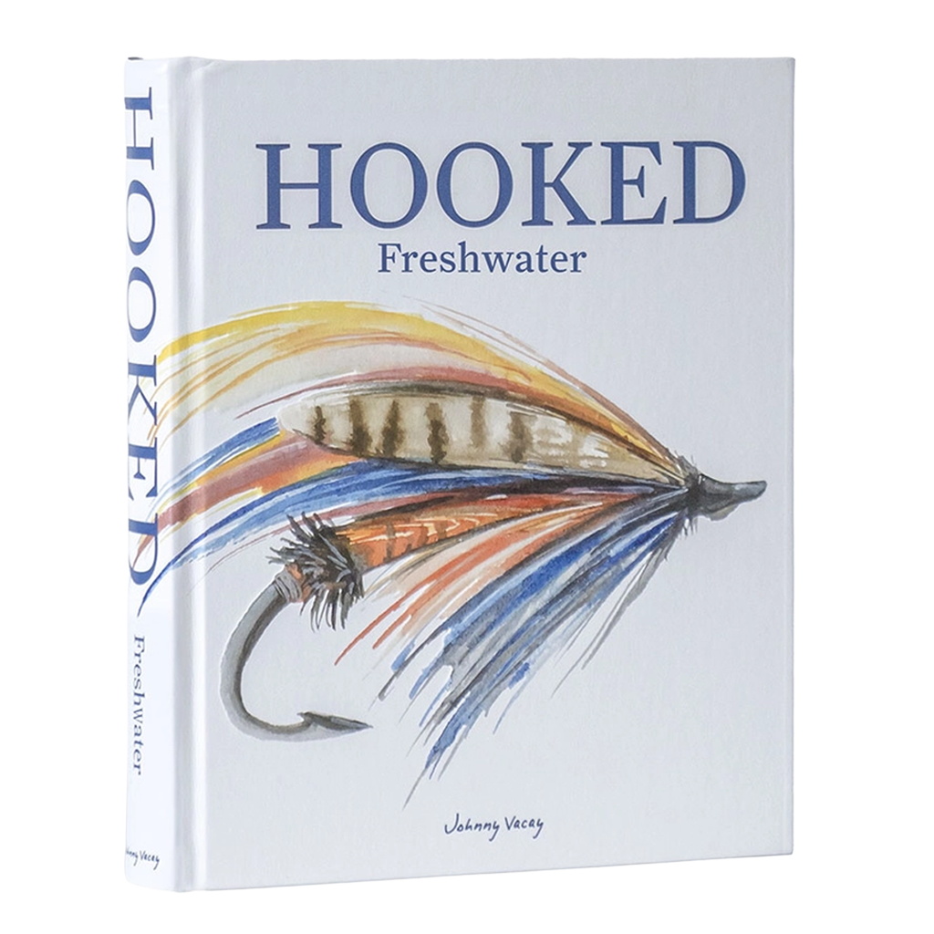 The book 'Hooked: Freshwater' by Johnny Vacay, featuring a white cover with a detailed illustration of a fly fishing lure in blue, orange, and brown, and blue title text.