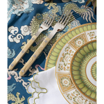 Decorative plate with intricate patterns on a blue patterned cloth