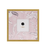 A framed intaglio artwork on a pink fabric background, enclosed in a gold frame.