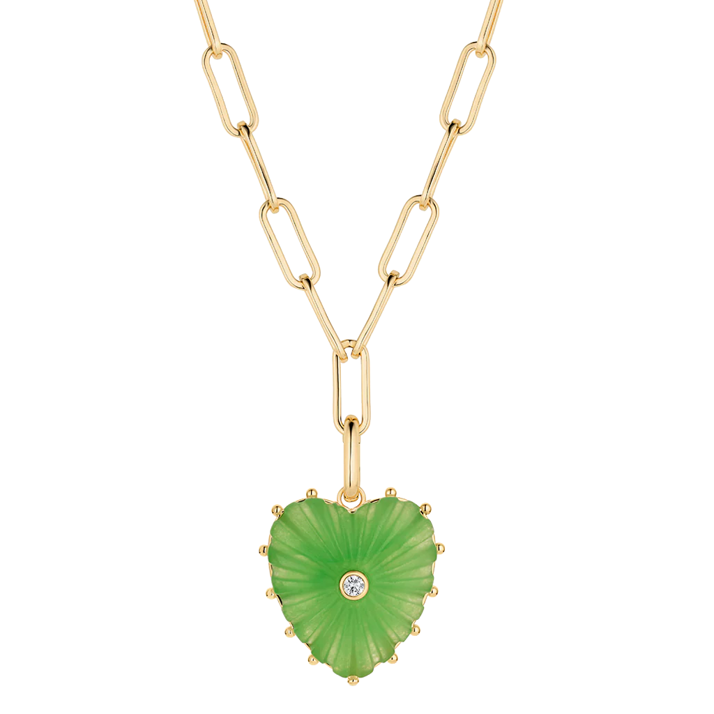 A gold paperclip chain necklace with a heart-shaped green stone pendant featuring a small clear gemstone in the center, shown on a plain white background.