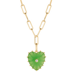 A gold paperclip chain necklace with a heart-shaped green stone pendant featuring a small clear gemstone in the center, shown on a plain white background.
