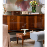 Close up of antique console styled with boxes, books and vase with flowers