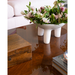 Floral arrangement in a white bowl on a wooden coffee table