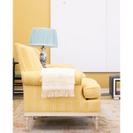 yellow chair next to a blue lamp with white art in the background