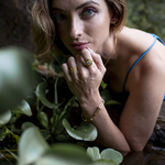 Woman with gold jewelry among plants