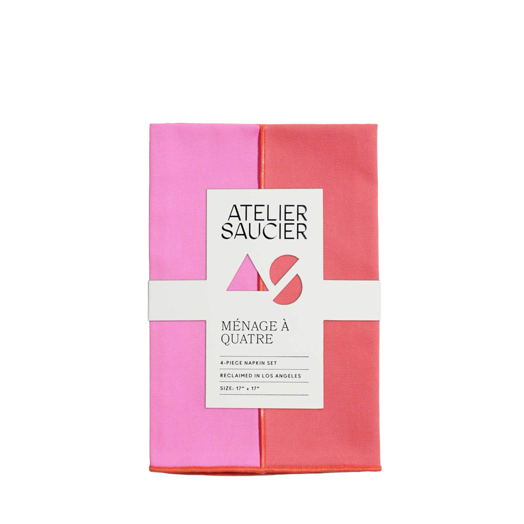 Folded pink and red napkin set with Atelier Saucier branding on a white background