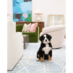 An antique walnut sideboard with bronze details, featuring a combination of drawers and doors, placed in a room with modern furniture. A dog is sitting in front of the sideboard.