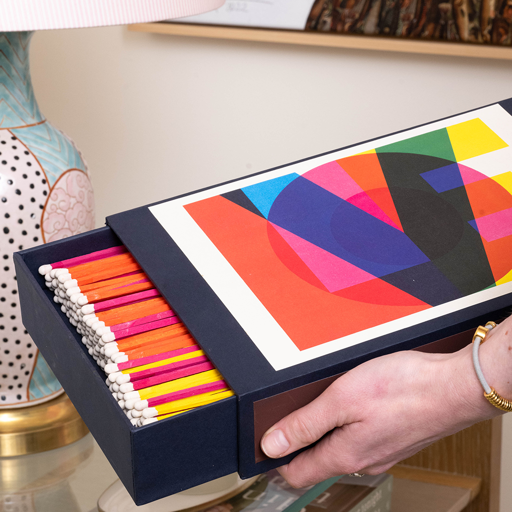 Giant matches in match box with word "LOVE" in colorful design.