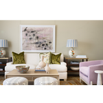 Living room with a white sofa, green cushions, and a painting on the wall.