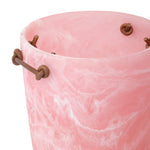 close up image of pink resin ice bucket with leather handles on a white background