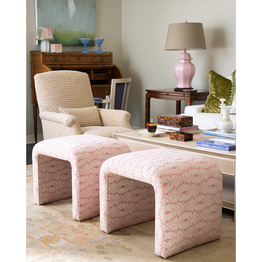 a pair of pink patterned ottomans in a living room vignette