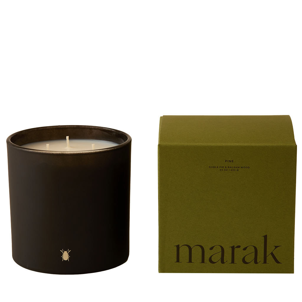 Black candle in a container with a green 'marak' box on a white background