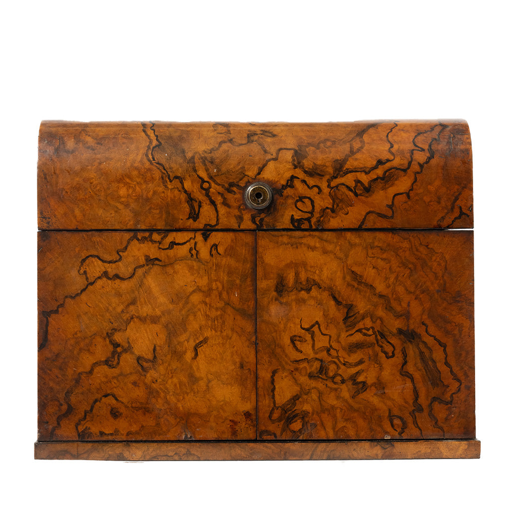 A rectangular rounded wooden box with a hinged top and front panel, featuring dramatic swirling burl wood grain in warm brown and amber tones, secured with a small round metal clasp, shown against a plain white background.