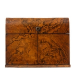 A rectangular rounded wooden box with a hinged top and front panel, featuring dramatic swirling burl wood grain in warm brown and amber tones, secured with a small round metal clasp, shown against a plain white background.