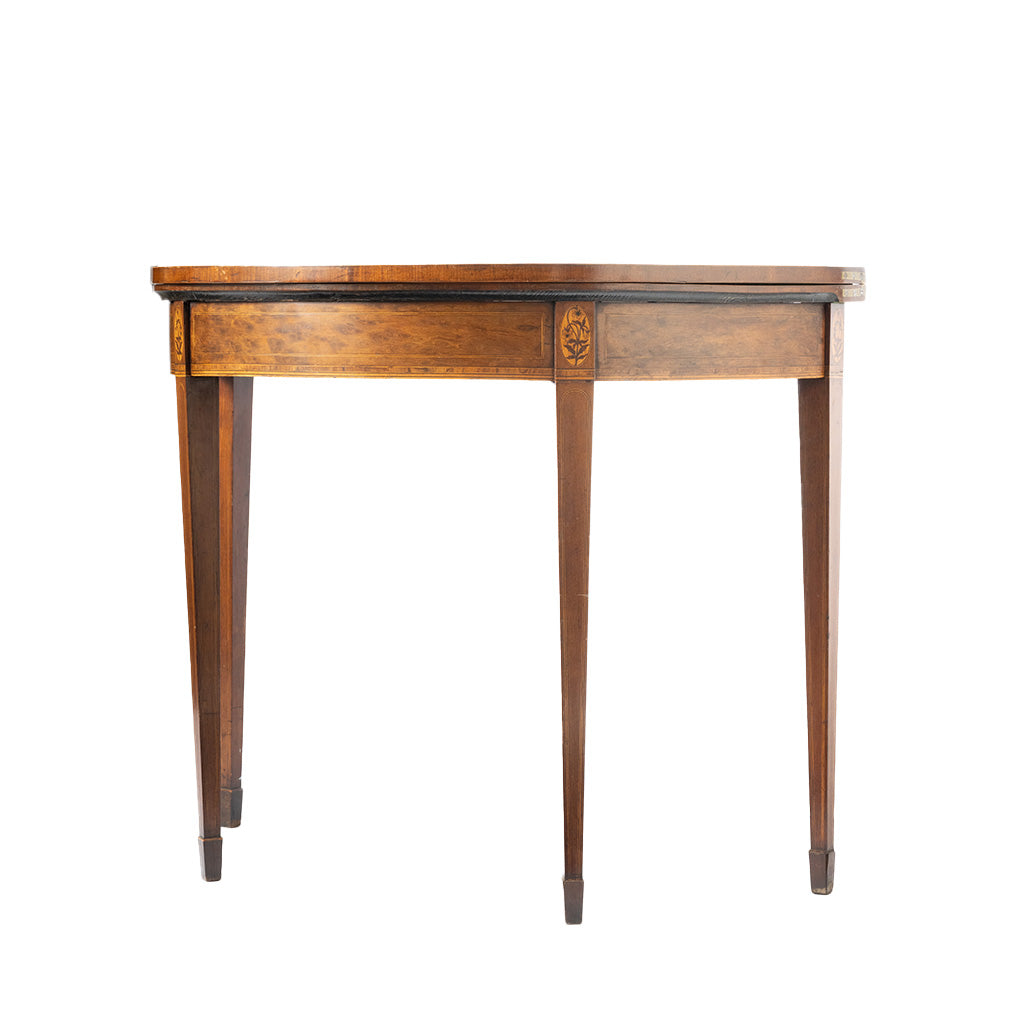 A vintage wooden demi-lune table, featuring a warm medium-brown wood finish, decorative carved details on the drawer front, and tapered legs, shown against a plain white background.