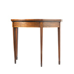 A vintage wooden demi-lune table, featuring a warm medium-brown wood finish, decorative carved details on the drawer front, and tapered legs, shown against a plain white background.