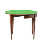 A compact wooden folding table with both semicircular leaves extended forms a round tabletop covered in bright green felt. The table features tapered legs, subtle floral inlay accents, and a warm wood finish, giving it an elegant antique appearance.