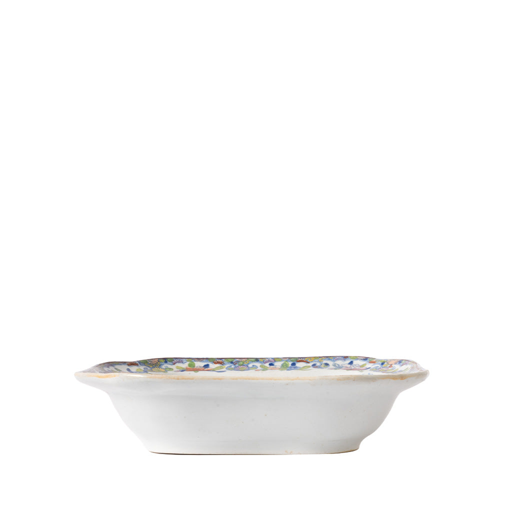 Side view of a square ceramic serving bowl with gently flared sides and a white exterior. A colorful floral border is visible around the rim, highlighting the bowl's decorative hand-painted design.