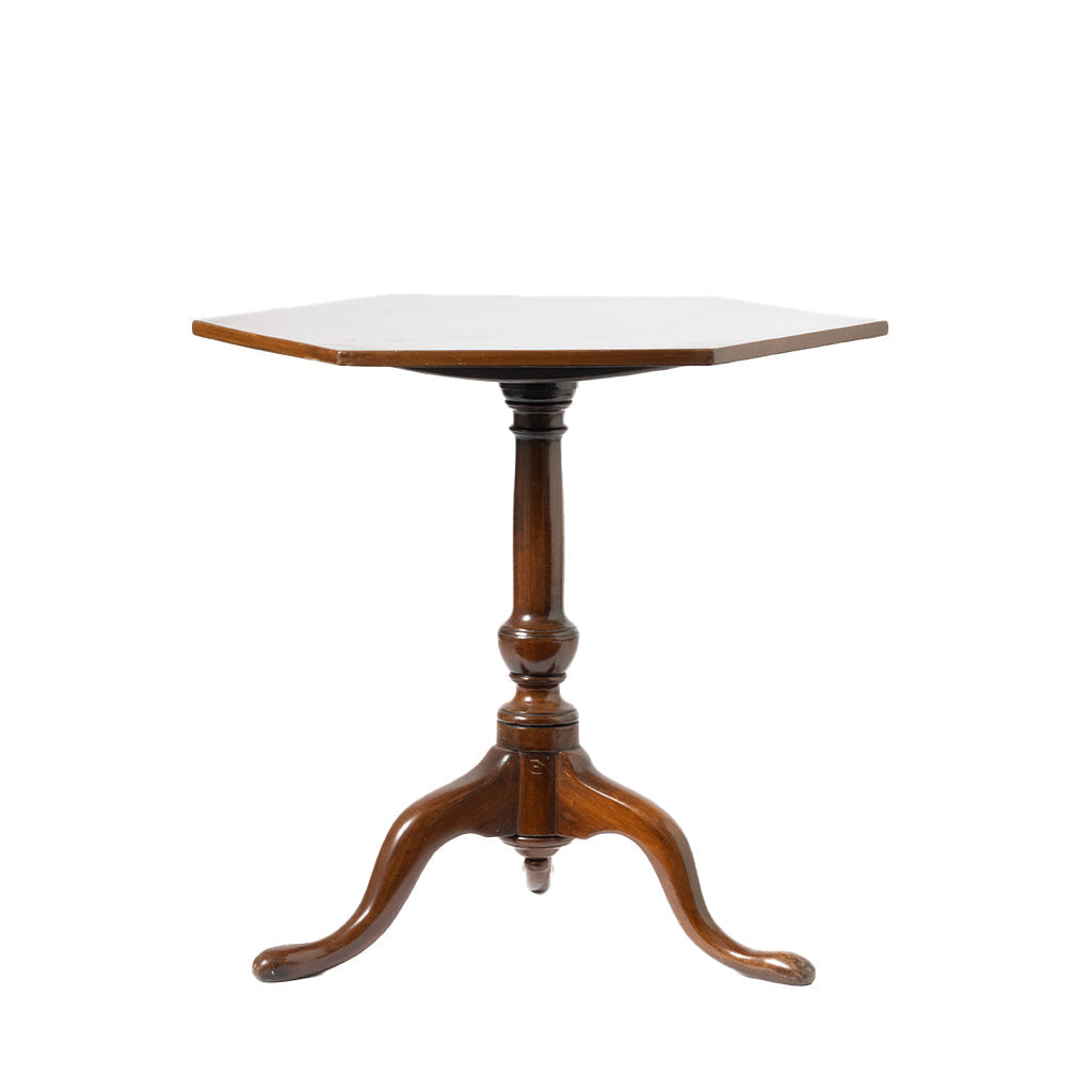 A hexagonal wooden pedestal table with a three-legged turned base, shown against a plain white background.