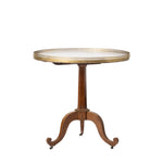 A round pedestal table with a gold brass mesh top and a curved brown wooden base on casters, shown against a plain white background.
