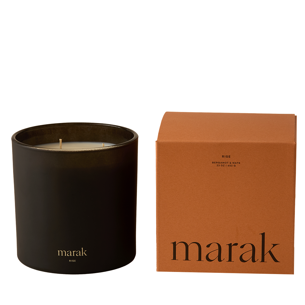 Black candle in a container with an orange box labeled 'marak' on a white background