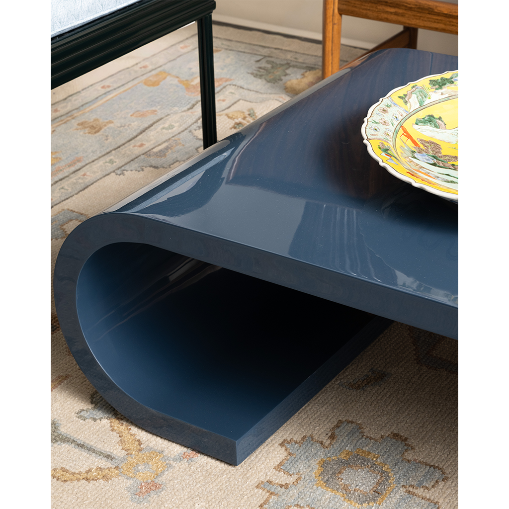 Blue coffee table with a decorative plate on a patterned rug