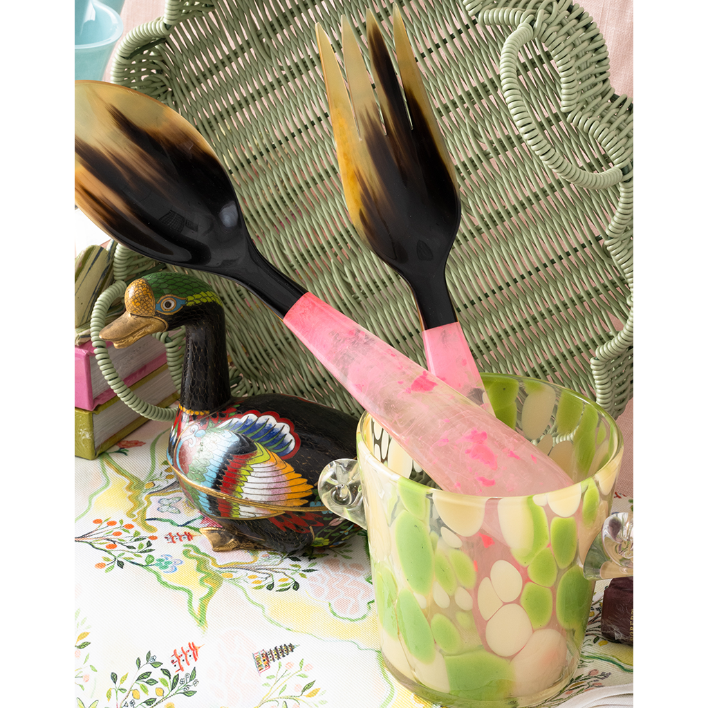 Decorative salad servers with a colorful ice bucket on a patterned surface